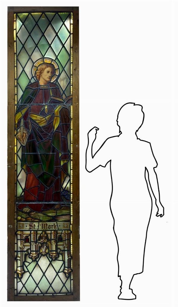 Antica vetrata rilegata a piombo con immagini a infusione nel vetro raffigurante San Mark, l'Evangelista. In telaio in legno, larga cm 6.H cm 255. Larghezza cm 60. Retroilluinata.
