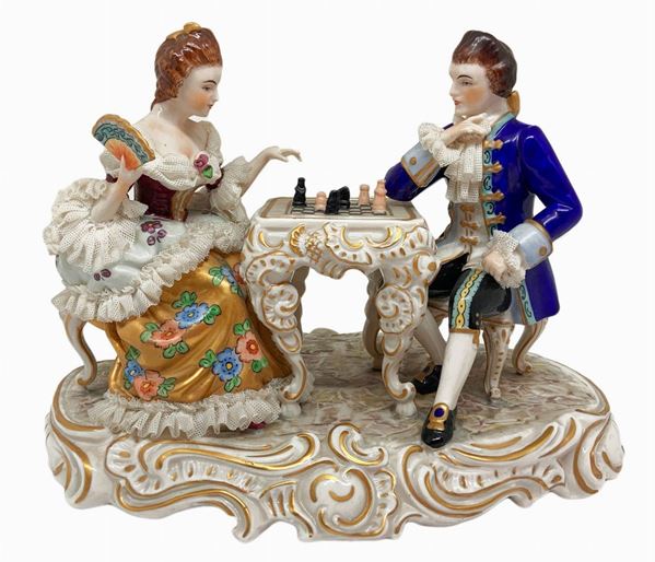 Capodimonte, statuina in porcellana raffigurante giocatori di scacchi, Napoli, XX secolo. H cm 16. Minime mancanze.