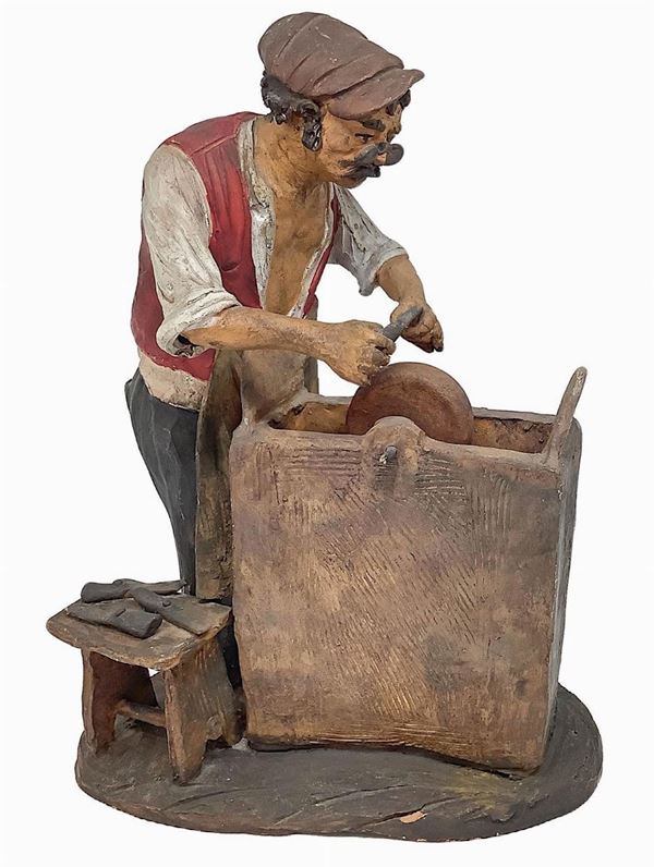 Scultura in terracotta policroma raffigurante arrotino. Firmato Romano, Caltagirone. H cm 24.