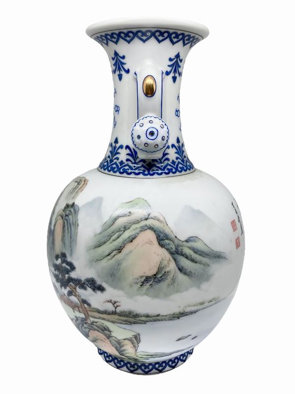 Vaso cinese biansato a fondo bianco, decorato nei toni del blu, rappresentazione di paesaggio di montagna sul fornte. 31 cm