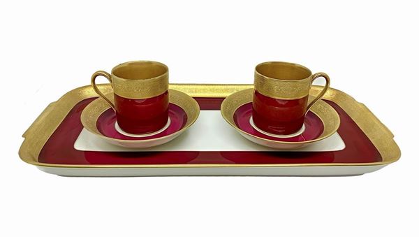 Piccolo servizio caffè tete a tete in porcellana Aofi Porzellan Manufaktur Bavaria,con decorazione in oro e rosso, composto da due tazzine con piattini e vassoio rettangolare. H tazzine con piattino cm 6,5. Vassoio cm 34x16