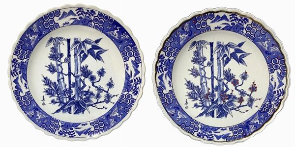 Pair of plates with blue decorations depicting bamboo and flowers.