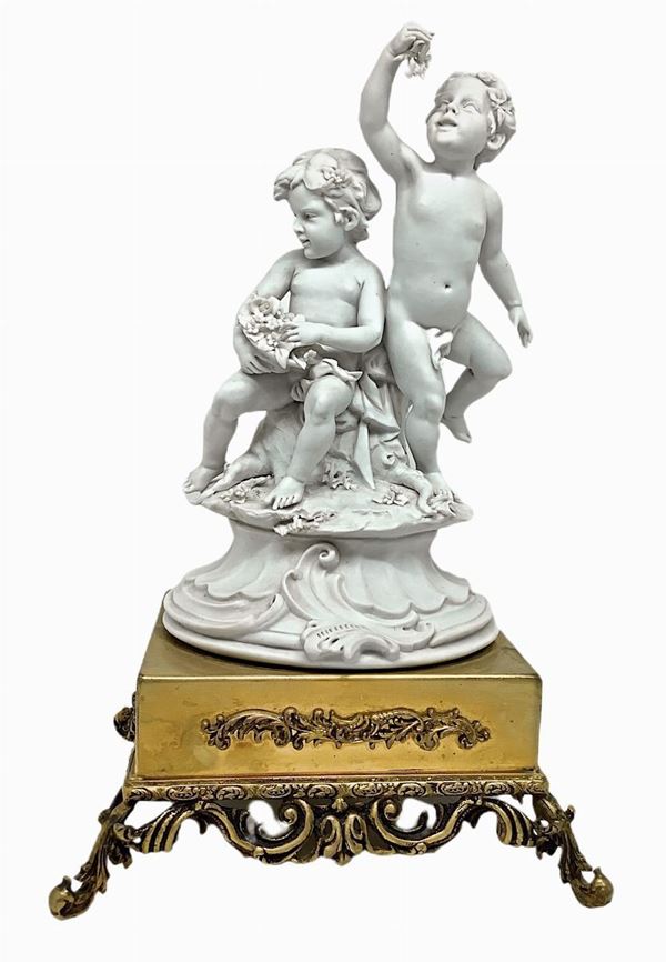 China in white biscuit depicting cherubs Pair of and golden brass base, twentieth century, signed Benacchio. Base 15x13 cm H 25 cm