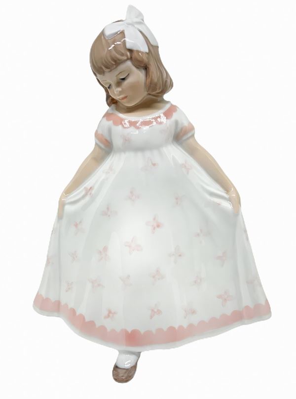Copenhagen porcelain figurine depicting a child with white dress and pink. H 22 cm