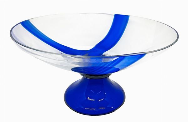 Grande alzata in vetro con base blu e coppa trasparente con inclusione di fasce blu. 
H cm 18,5 Diametro cm 35.
 Piccola sbeccatura