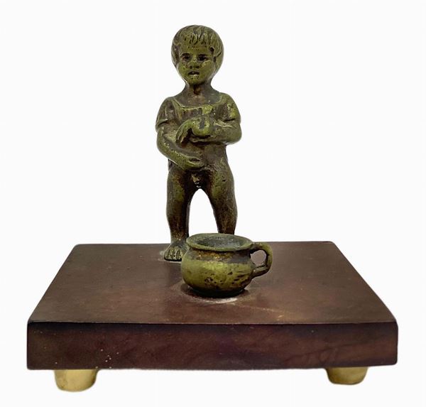 Piccolo bronzo raffigurante bambino con vasetto, XX secolo. H cm 6,2. Base cm 7,5x6x1.