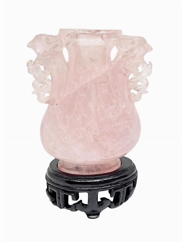 Piccolo vaso in quarzo rosa con base in legno.