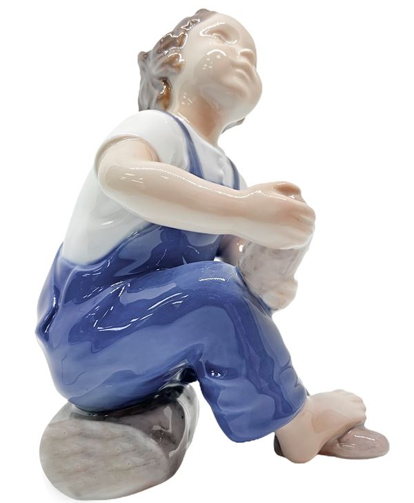 Copenhagen porcelain figurines depicting child with slipper. H 14 cm