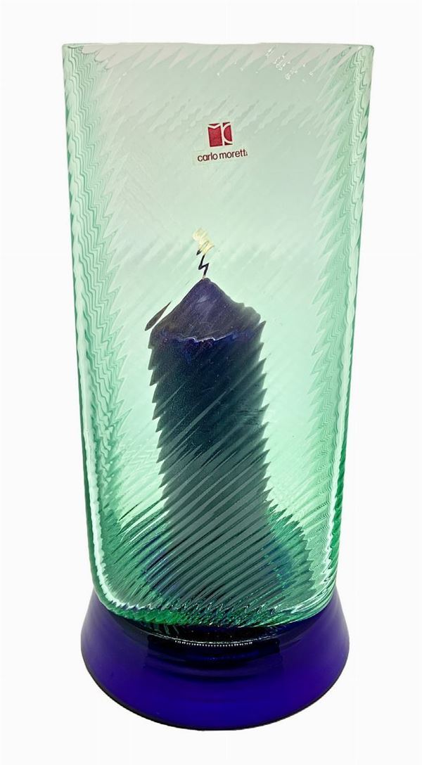 Portacandela produzione Carlo Moretti e base circolare. in vetro blu e diffusore in vetro verde con sottili costolature.
H cm 28. Diametro cm 14