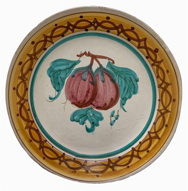 Piatto in maiolica dipinto a mano con decoro raffigurante melanzane, dipinto a mano, XX secolo, Sicilia. Diametro cm 37.

