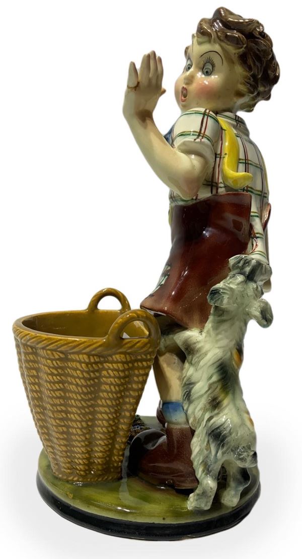 Scultura in terraglia raffigurante bambino con cane e cesto